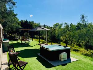 a backyard with a hot tub in the grass at Ca' Degli Ulivi Relax - uso esclusivo con jacuzzi in Lunigiana vicino cinque terre in Agnino