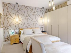 a bedroom with two beds and a geometric wall at St Cyriacs - Chichester in Chichester