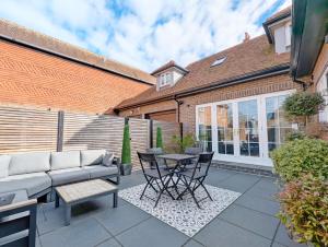 a patio with a couch and a table and chairs at St Cyriacs - Chichester in Chichester