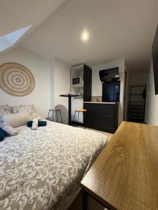 a bedroom with a large bed and a kitchen at Le studio louana Appartement neuf et discret tout confort in Aubusson