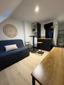 a living room with a blue couch and a table at Le studio louana Appartement neuf et discret tout confort in Aubusson
