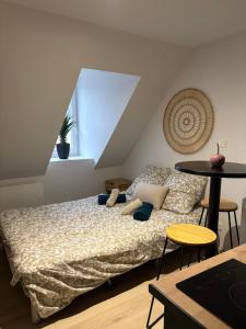 a bedroom with a bed with pillows and a table at Le studio louana Appartement neuf et discret tout confort in Aubusson