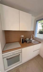 a kitchen with white cabinets and a sink and a window at Nid douillet à Cassis in Cassis