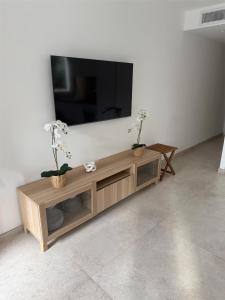 a flat screen tv sitting on top of a wooden entertainment center at Nid douillet à Cassis in Cassis