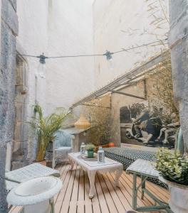 un patio con tavolo e sedie su un ponte di legno di Les Fougères #MaisonSavaron a Clermont-Ferrand