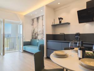 a kitchen and living room with a table and a couch at Appartamenti Pamar in Civitanova Marche