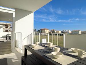 a wooden table with bowls on top of a balcony at Appartamenti Pamar in Civitanova Marche