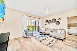 a living room with a couch and a table at Near Disney - 2BR Condo - Balcony Pool Hot Tub in Orlando +19 photos
