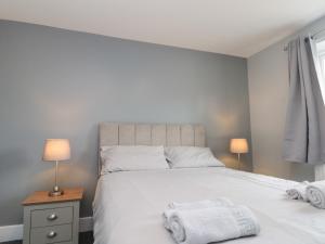 a bedroom with a white bed with two towels on it at Ivy in Filey
