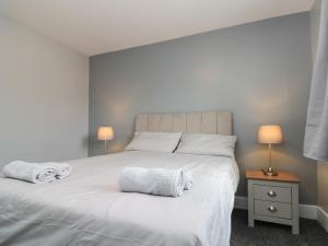 a bedroom with a large white bed with towels on it at Ivy in Filey