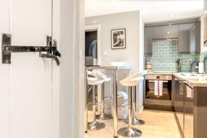 eine Küche mit Barhockern in der Mitte eines Raumes in der Unterkunft Mills Cottage - 1 parking space in Henley on Thames + 24 Fotos
