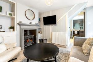 ein Wohnzimmer mit Tisch und Kamin in der Unterkunft Mills Cottage - 1 parking space in Henley on Thames
