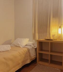 a bedroom with a bed and a table with a lamp at Vergel San Pedro in Torremenga