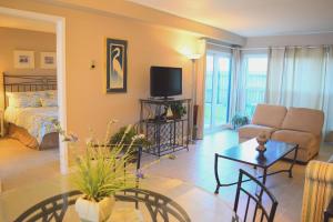 Una sala de estar con una cama, un sofá y una mesa. en Emerald Isle 105 by Alicia Hollis Rentals, en Fort Walton Beach