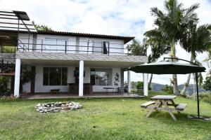 a house with a picnic table and an umbrella at Hostal Santa Teresita in La Merced
