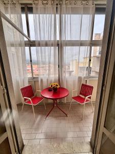 a table and two chairs in a room with a window at Appartamento turistico Giarre in Giarre +17 photos