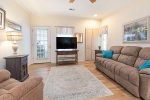 a living room with a couch and a flat screen tv at Greenside Hideaway - In the heart of Branson in Branson
