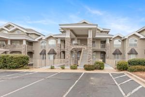 a large apartment building with a parking lot at Greenside Hideaway - In the heart of Branson in Branson +16 photos