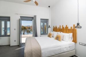 阿达玛斯Almyra House的卧室里有一张白色的大床和一扇窗户