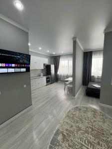 カラガンダにあるЖк Асыл Парк Юго востокの大画面薄型テレビ付きの広いリビングルーム