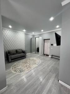 カラガンダにあるЖк Асыл Парк Юго востокのソファとラグのあるリビングルーム