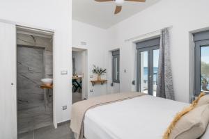 a bedroom with a white bed and a stone wall at Almyra House in Adamantas