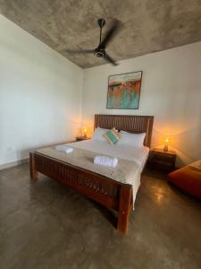 a bedroom with a large bed with two lamps at Stonewater Beach Villa, Negombo in Mahawatta