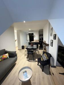 a living room with a couch and a table at La Villa Louana 4 Appartement neuf et moderne tout confort in Aubusson