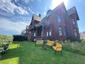 a house with three benches in front of it at Blue Ocean Seaview Penthouse Perfectly Saltburn in Saltburn-by-the-Sea