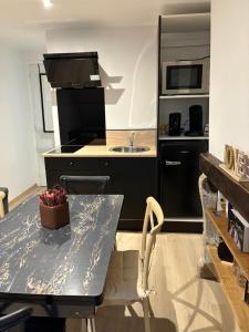 a kitchen with a table with a sink and a stove at La Villa Louana 4 Appartement neuf et moderne tout confort in Aubusson +11 photos