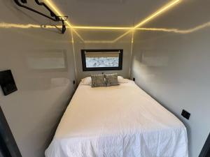 圣玛丽亚港The Boathouse Company - Casa flotante experience - Real Club Náutico, El Puerto de Santa María的一个小房间的小床,设有窗户