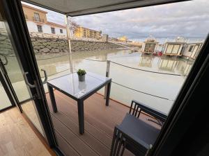 圣玛丽亚港The Boathouse Company - Casa flotante experience - Real Club Náutico, El Puerto de Santa María的带桌子的阳台，可欣赏水景