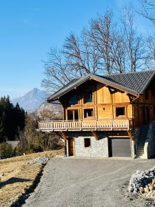 a large wooden house on a hill with a driveway at Chalet Monarch - Les Carroz - Sauna, Spa & vue Montagnes in Arâches-la-Frasse