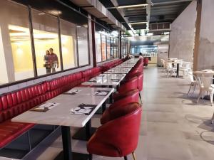 a row of tables in a restaurant with red seats at Kozi Square, Kozi 8 in Kuching