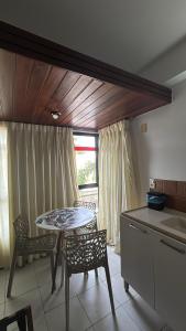 uma cozinha com mesa e cadeiras em uma sala em Apart-Hotel em Tambaú - Super Central com Vista Mar - Ap.113 em João Pessoa