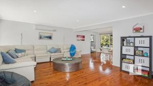 a living room with a couch and a table at The Little Blue Lakehouse in Summerland Point