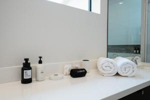 a bathroom counter with towels and products on it at Space City - Prof Design, Game Room, King BD in Houston +38 photos