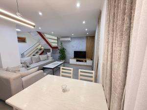 a living room with a table and a couch at Luxury sea view duplex in Durrës