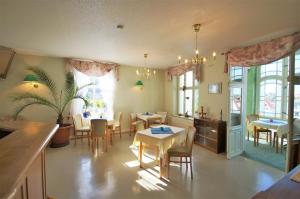 a dining room with tables and chairs and windows at Hotel Am Kurpark in Bad Suderode