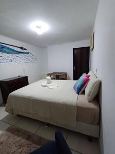 a bedroom with a bed and a boat on the wall at Suite Térrea in Bombinhas