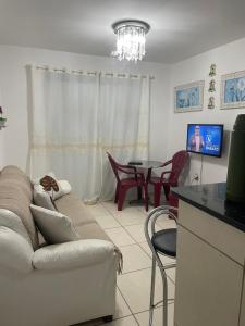 un soggiorno con un divano e un tavolo con sedie di Jacumã AP a Conde