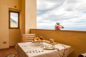 a table with a plate of food and a window at Villa Gea in Praiano