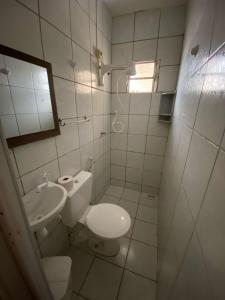 a white bathroom with a toilet and a sink at Residencial Dragão in Fortaleza +102 photos