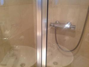 um chuveiro com uma porta de vidro e um WC em Hotel Sergul em Londres
