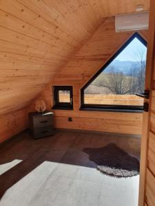 a room with a large window in a wooden cabin at Górskie chatki w Wiśle in Wisła