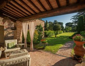 eine Außenterrasse mit einer Pergola und einem Sofa und einem Stuhl in der Unterkunft Casa Francesca in Gambassi Terme