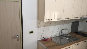 a kitchen with a sink and white cabinets at Kris's Studio in Lezhë