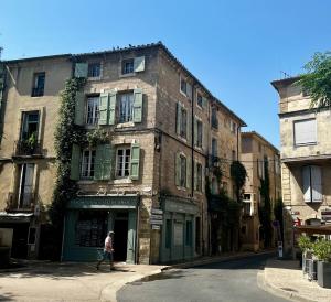 ペズナにあるUpscale townhouse in centre Pézenasの古い建物の前を歩く女
