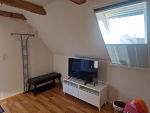 a living room with a flat screen tv and a window at Ferienwohnungen Dümmersee - Haus Dümmerland - Wohnung 4 in Hüde +19 photos