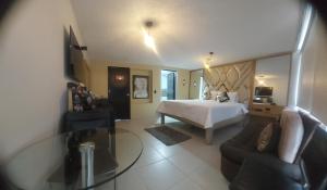 a hotel room with a bed and a glass table at Hotel Boutique San Sebastián Chapinero in Bogotá
